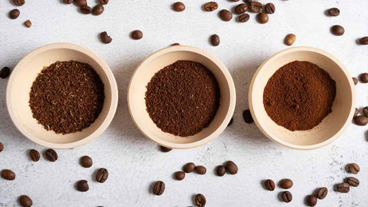 Kaffeebohnen neben einer Kaffeemühle – Symbol für den richtigen Mahlgrad bei der Zubereitung